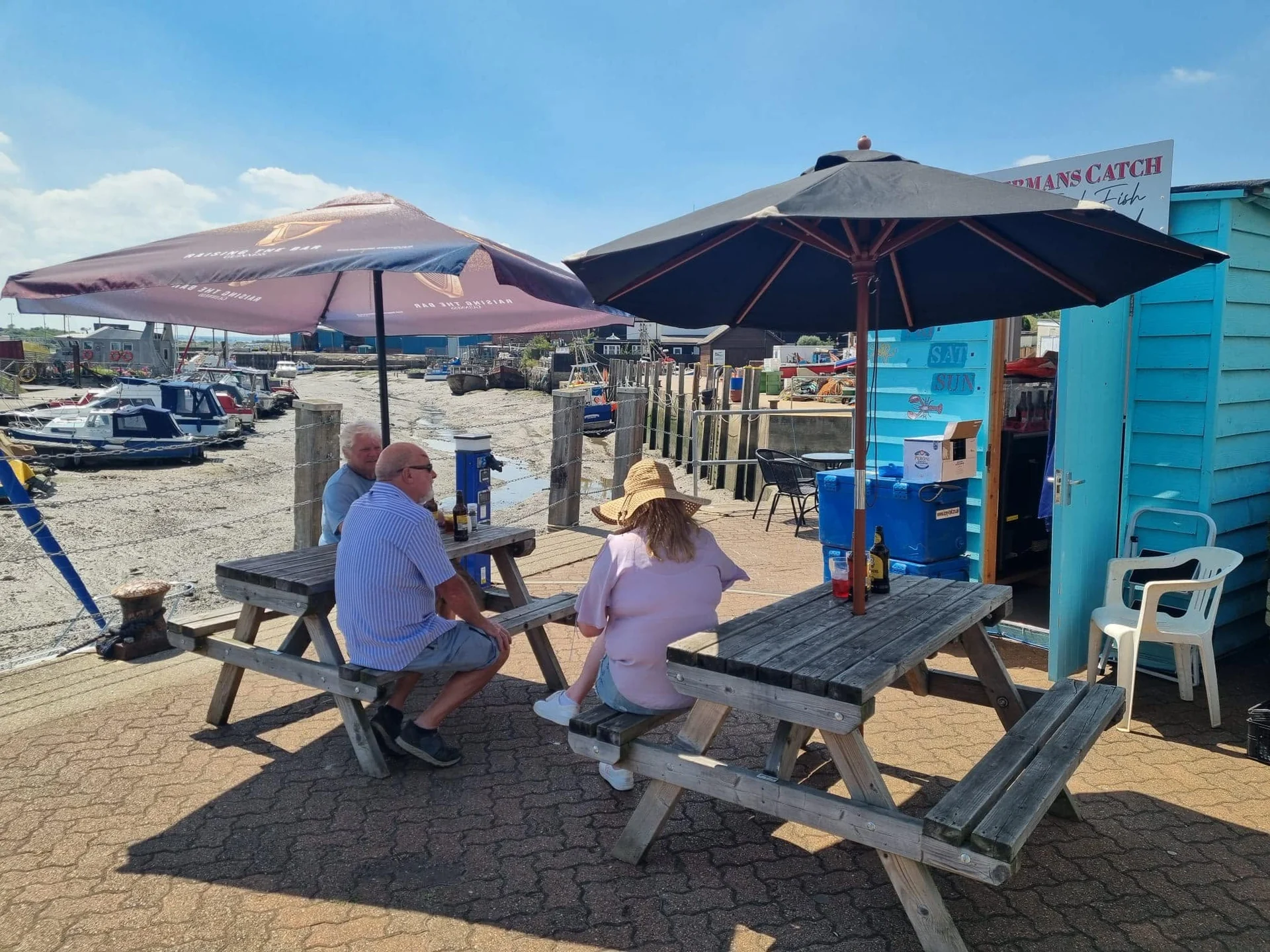 Customers seated beside The Little Blue Hut overlooking Queenborough harbour